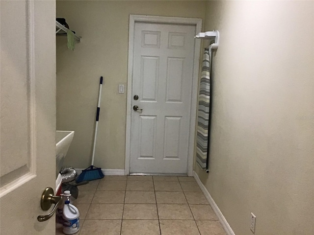 clothes washing area with light tile patterned floors