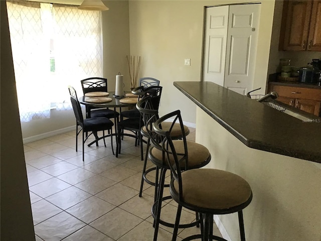 dining area with sink and light tile patterned flooring