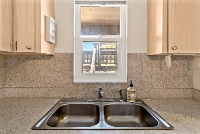 kitchen with tasteful backsplash, sink, and light brown cabinetry