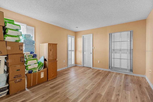 unfurnished room with light hardwood / wood-style floors and a textured ceiling