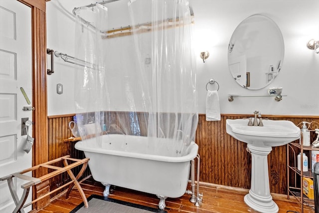 bathroom featuring independent shower and bath, wooden walls, and hardwood / wood-style floors