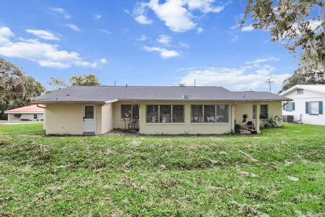 back of house featuring a yard and central air condition unit