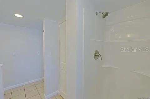 bathroom with walk in shower and tile patterned floors