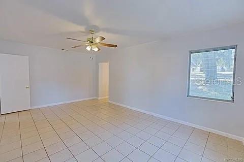 unfurnished room featuring ceiling fan and light tile patterned floors