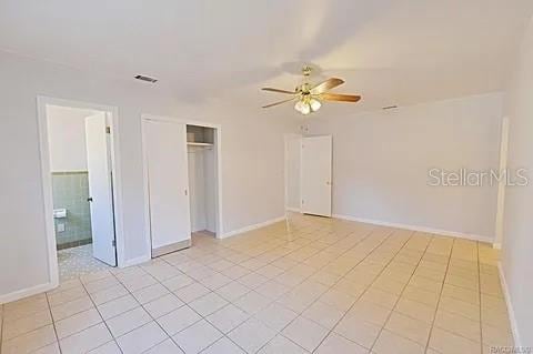 tiled empty room featuring ceiling fan