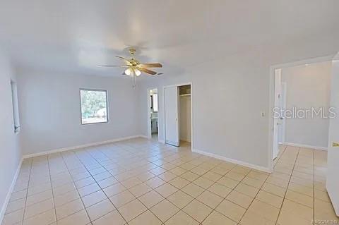 empty room featuring ceiling fan and light tile patterned floors