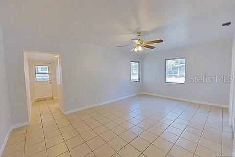 tiled empty room featuring ceiling fan