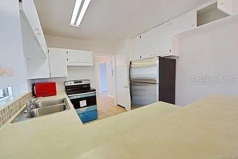 kitchen featuring stainless steel appliances, sink, and white cabinets