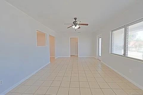 spare room featuring light tile patterned flooring and ceiling fan