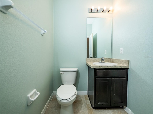 bathroom with toilet, vanity, and tile patterned floors