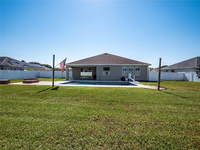 rear view of property featuring a patio, a fire pit, and a yard