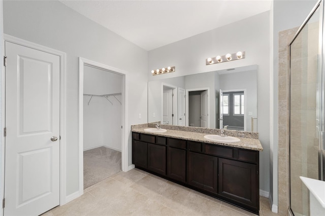 bathroom featuring tile patterned floors, vanity, and a shower with shower door