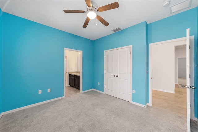 unfurnished bedroom featuring light carpet, connected bathroom, a closet, and ceiling fan