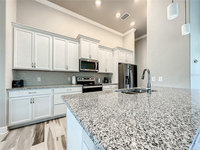 kitchen featuring light stone counters, appliances with stainless steel finishes, and white cabinets