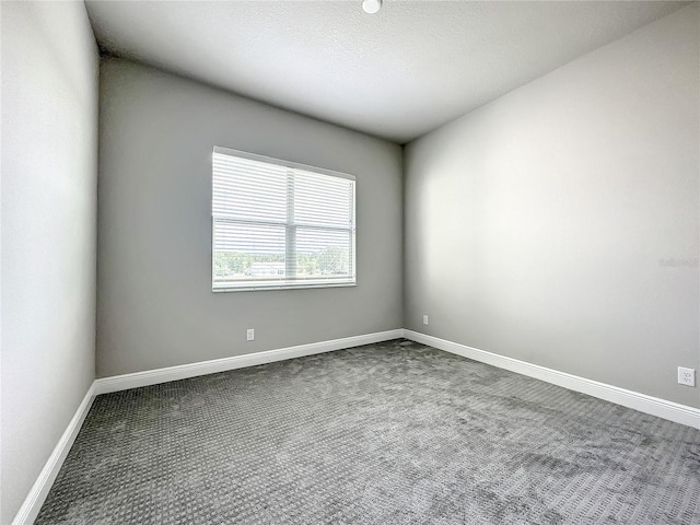 carpeted empty room with a textured ceiling