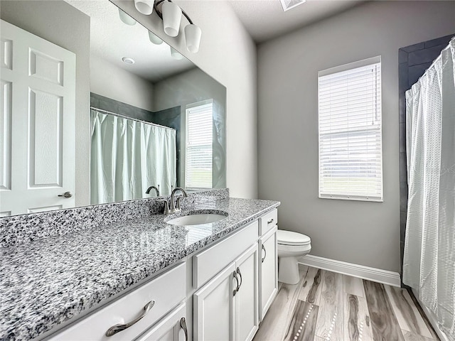 bathroom featuring vanity, hardwood / wood-style flooring, toilet, and a shower with shower curtain