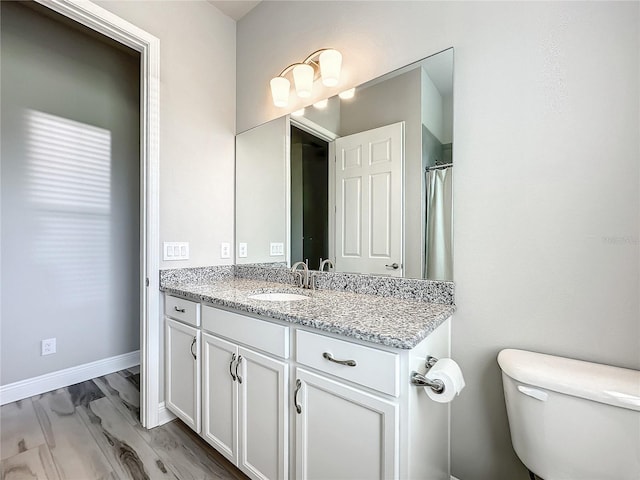 bathroom with vanity, hardwood / wood-style floors, and toilet