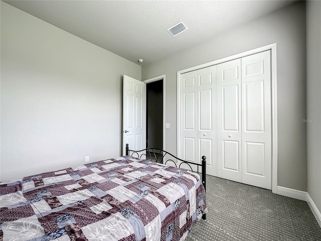 carpeted bedroom featuring a closet and a textured ceiling