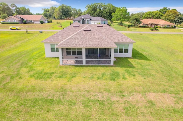 back of house featuring a yard and a sunroom