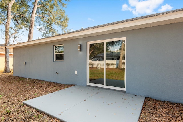 rear view of property with stucco siding and a patio