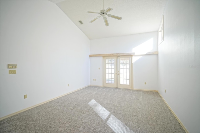 carpeted empty room featuring vaulted ceiling, ceiling fan, and french doors