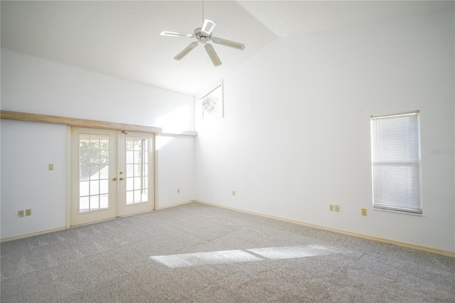 carpeted spare room featuring high vaulted ceiling, ceiling fan, and french doors