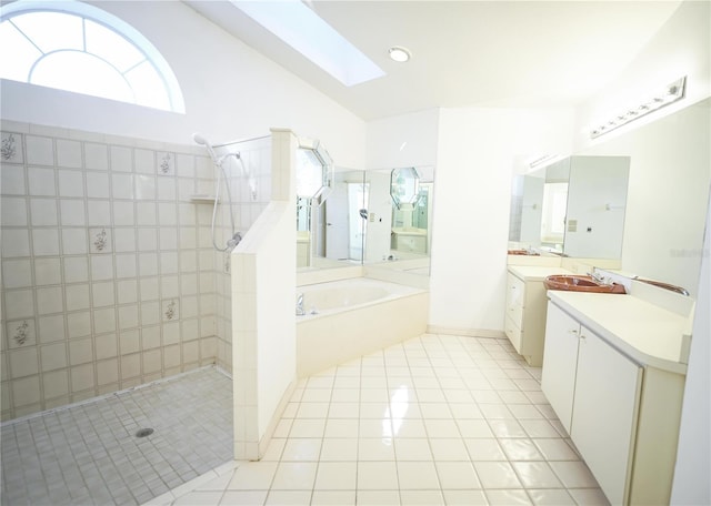 bathroom with plus walk in shower, a skylight, tile patterned floors, and vanity