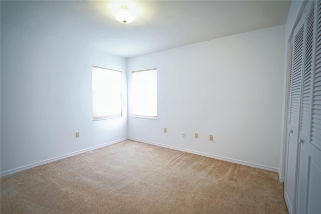 unfurnished bedroom featuring light colored carpet and a closet