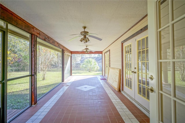 unfurnished sunroom with ceiling fan and french doors