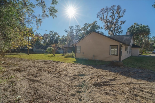 4215 SE 24th Ter, Ocala, FL 34480 - view of side of home with a chimney and a lawn