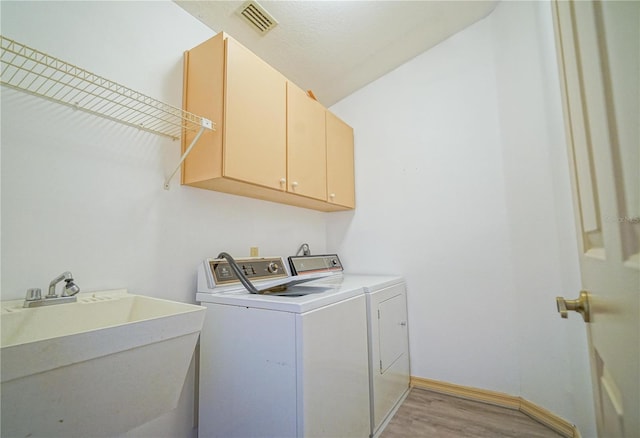 4215 SE 24th Ter, Ocala, FL 34480 - laundry room featuring cabinet space, light wood-type flooring, independent washer and dryer, and baseboards