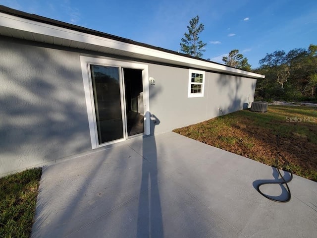 view of property exterior with a patio and central AC