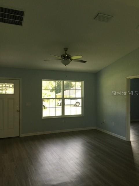 spare room with dark wood-type flooring and ceiling fan