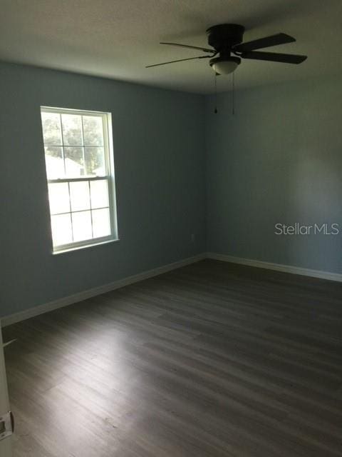 unfurnished room featuring dark hardwood / wood-style floors and ceiling fan