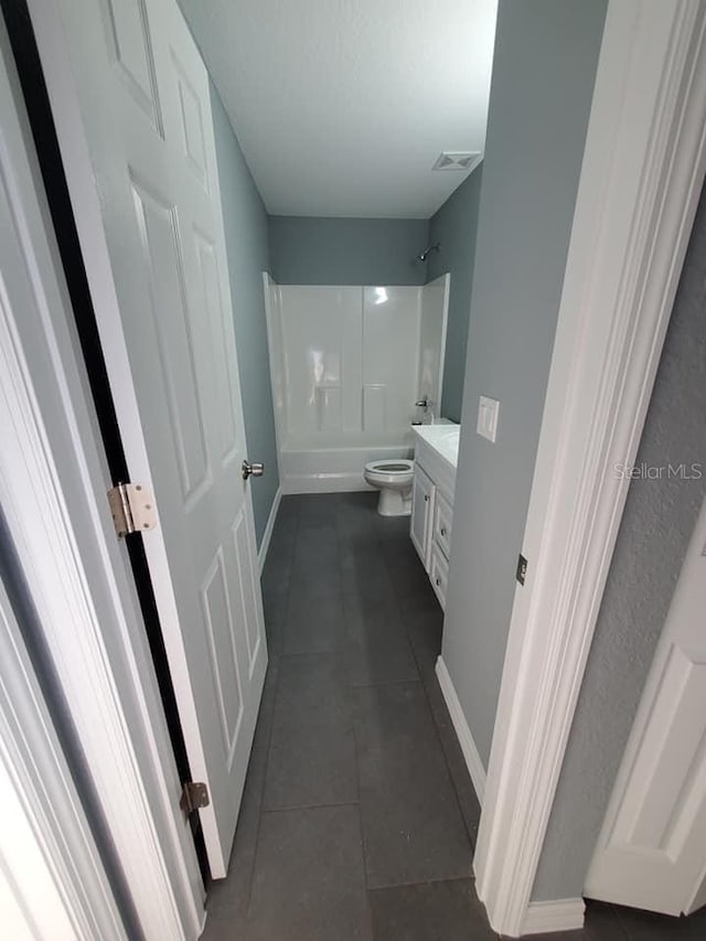 full bathroom with toilet, vanity, washtub / shower combination, and tile patterned flooring