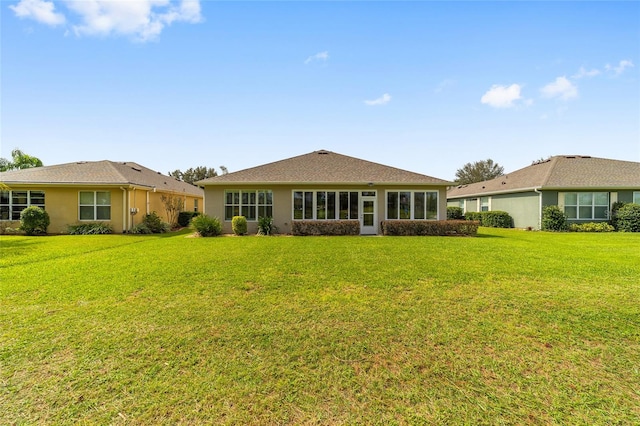 rear view of property featuring a lawn