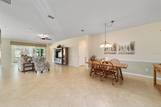 tiled dining area with ceiling fan with notable chandelier