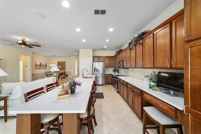 kitchen with backsplash, sink, a breakfast bar area, a large island, and stainless steel appliances