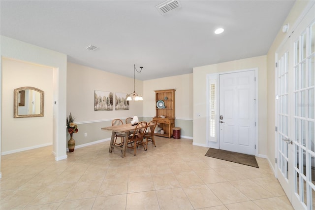 dining room with light tile patterned floors, a wealth of natural light, and a notable chandelier