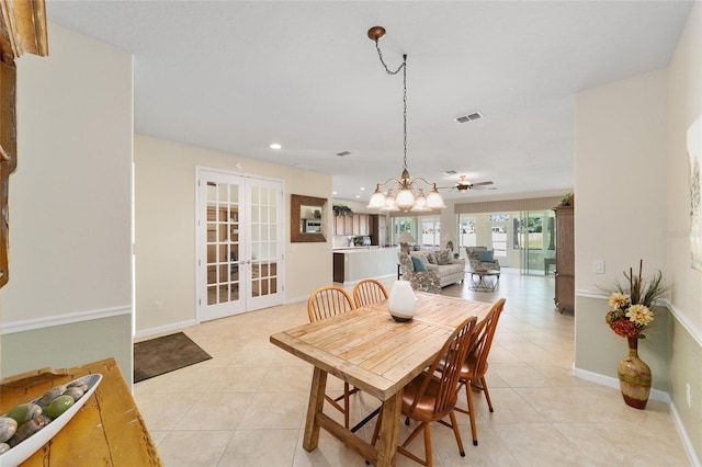 dining room with french doors, light tile patterned floors, and ceiling fan with notable chandelier