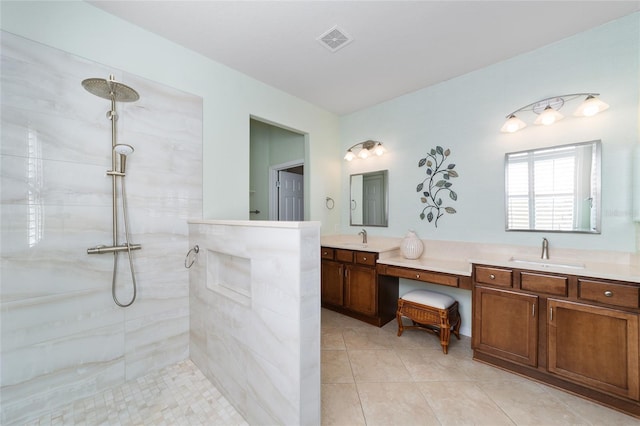 bathroom with a tile shower, tile patterned floors, and vanity