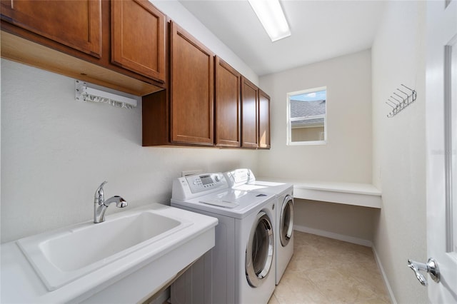 laundry room with washer and clothes dryer, sink, light tile patterned floors, and cabinets