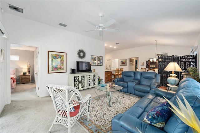 living room featuring ceiling fan with notable chandelier, light colored carpet, and lofted ceiling