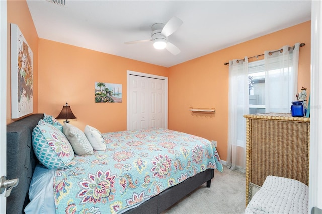 carpeted bedroom with ceiling fan and a closet