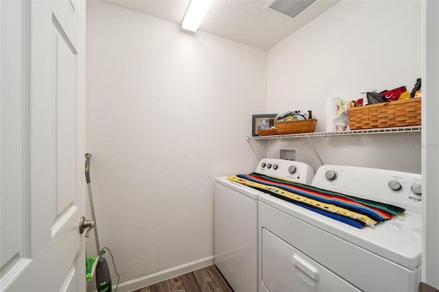 clothes washing area featuring dark hardwood / wood-style floors and washing machine and clothes dryer