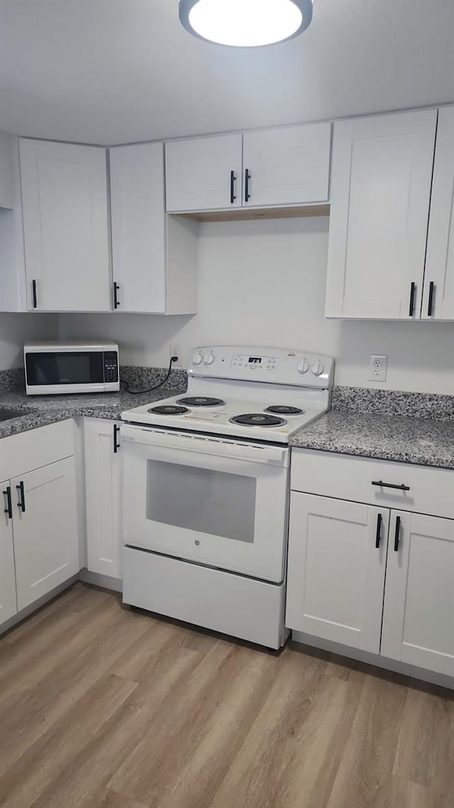 kitchen with light hardwood / wood-style floors, white cabinetry, and white electric range