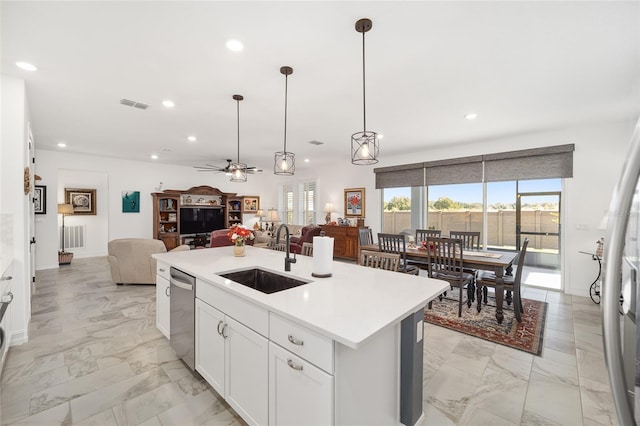 kitchen with white cabinets, ceiling fan, an island with sink, pendant lighting, and sink