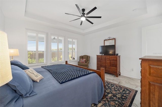 bedroom with a tray ceiling and ceiling fan