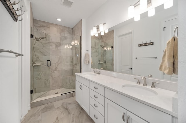 bathroom featuring a shower with door and vanity