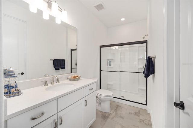 bathroom featuring vanity, a shower with shower door, and toilet